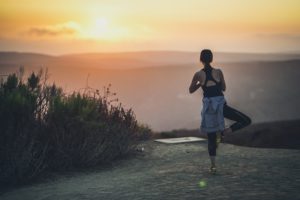 Person practicing yoga at sunrise