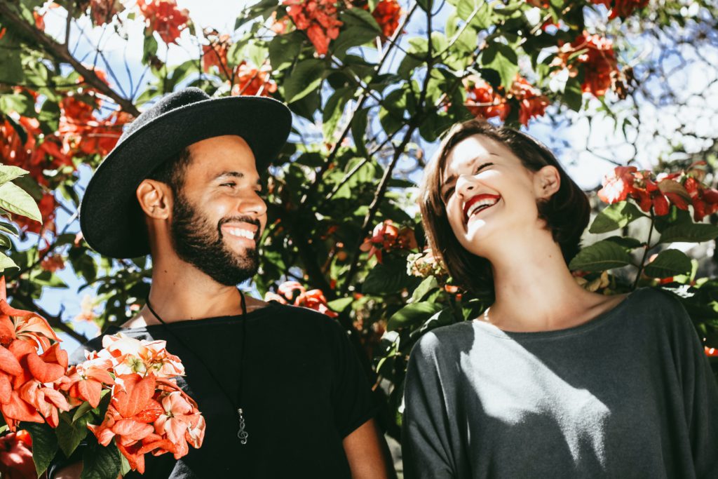 Two people laughing under a tree