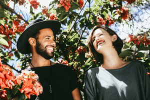Two people laughing under a tree