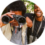 People smiling and looking through binoculars