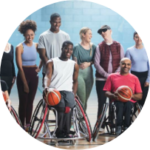 Group of people in sports attire, two wheelchair basketball players are in the foreground